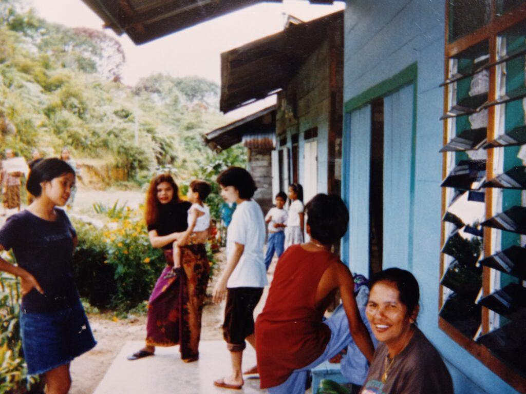 Faridas' family at their former house in Parlilitan North Sumatra. Seven family members can be seen here and Farida is holding our first son.
