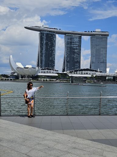 Farida posing at Marina Bay with the Marina Bay Sands Hotel in the background.